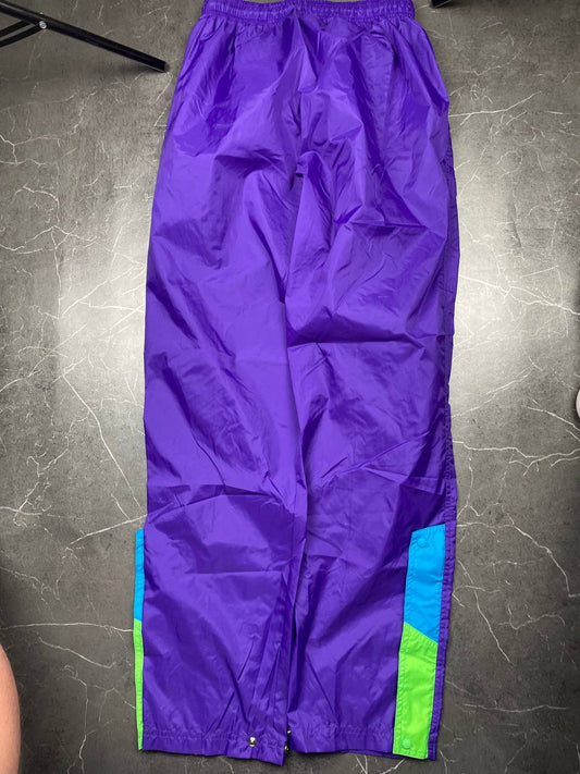 Nike track pants purple with blue and green accents, nylon material, elastic waistband.