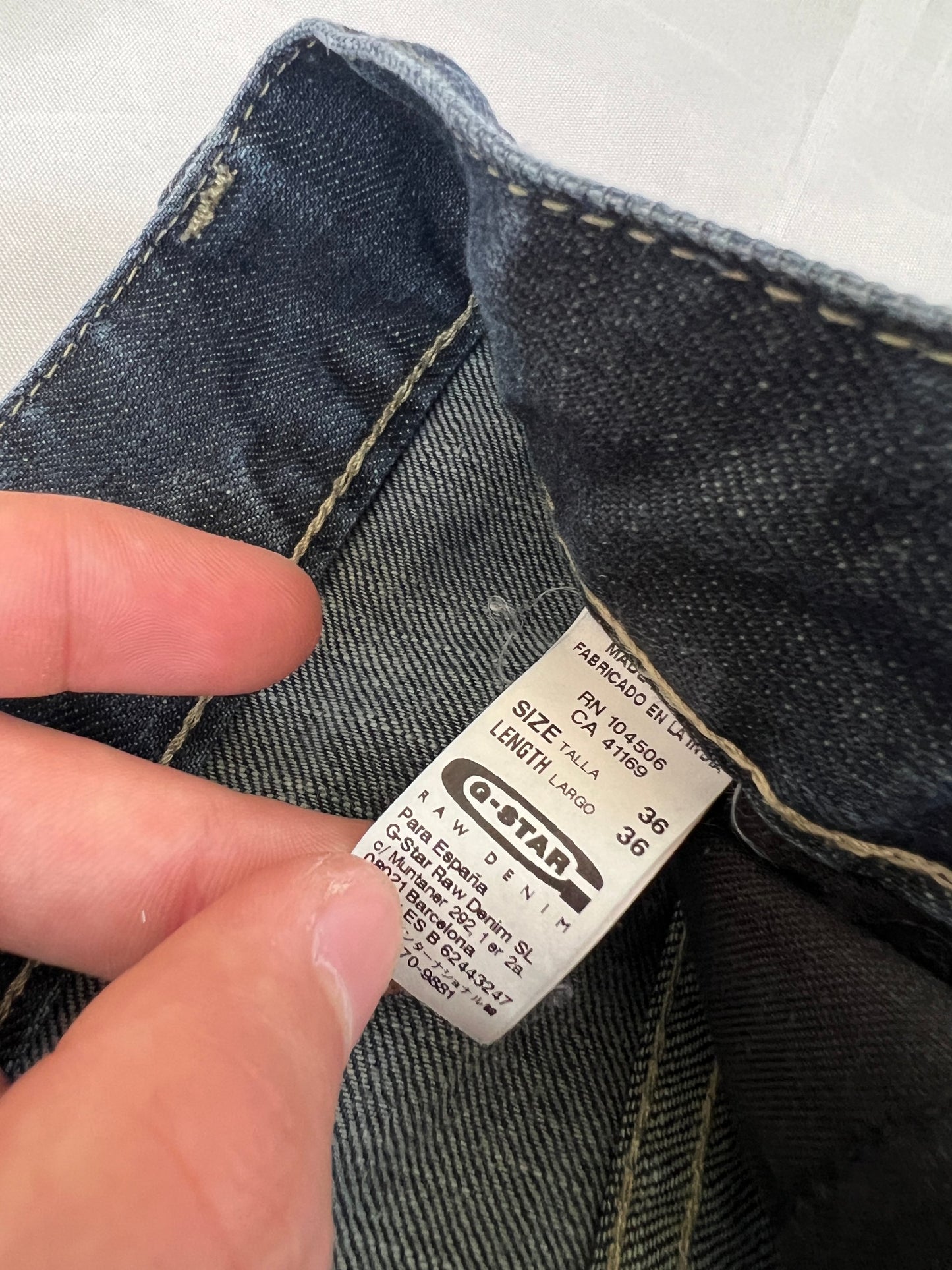 G-Star Raw blue denim jeans with embroidered logo, distinctive seam detailing, and large back pockets.