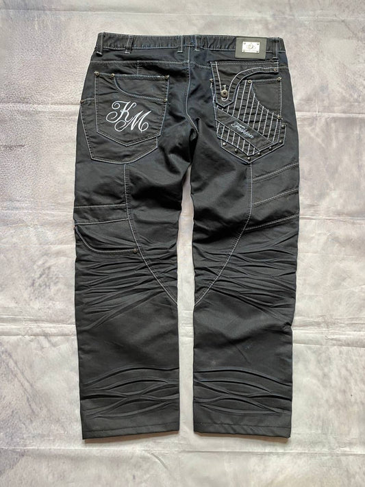 K&M black jeans size 38 with detailed white stitching and metallic stud accents.