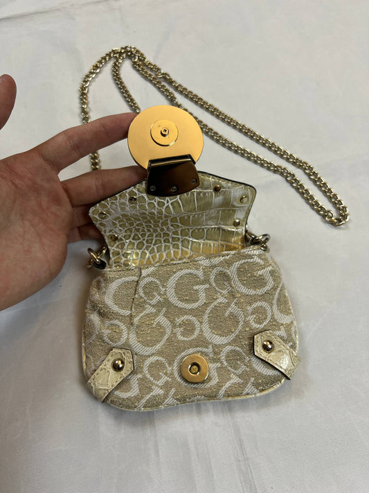 Guess beige mini crossbody bag with white signature print and gold-tone chain strap.
