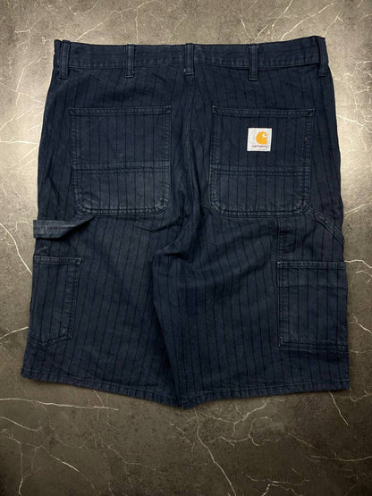 Carhartt navy shorts with pinstripe pattern, utility pockets, and branded metal button.