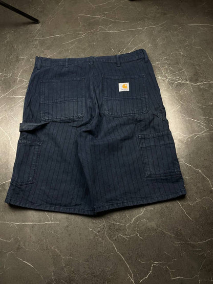Carhartt navy shorts with pinstripe pattern, utility pockets, and branded metal button.