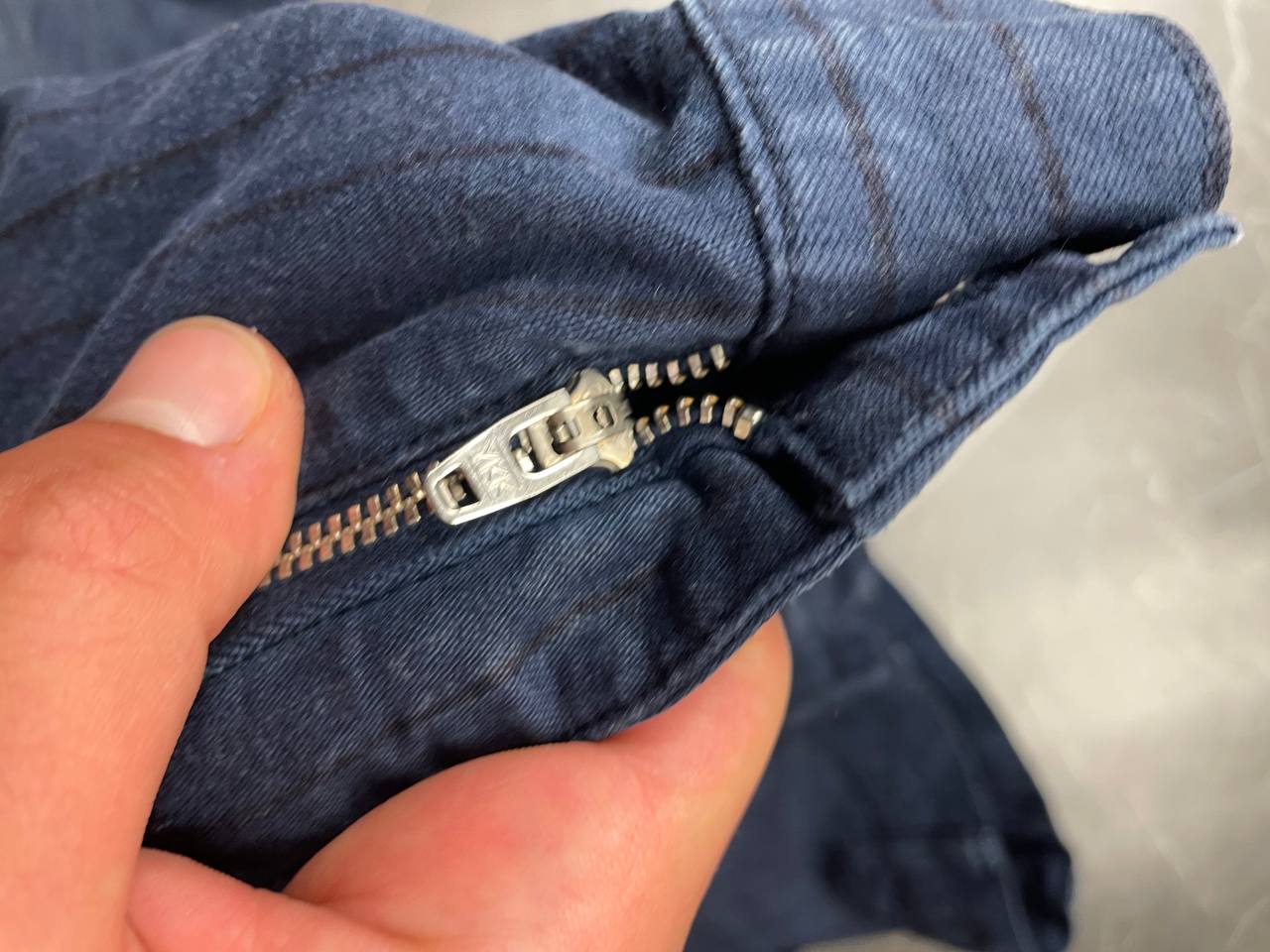 Carhartt navy shorts with pinstripe pattern, utility pockets, and branded metal button.