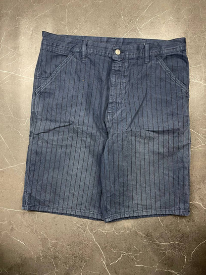 Carhartt navy shorts with pinstripe pattern, utility pockets, and branded metal button.
