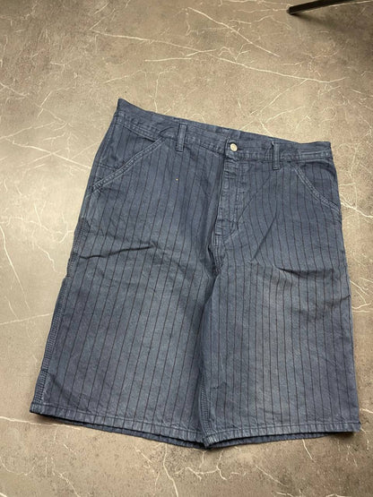 Carhartt navy shorts with pinstripe pattern, utility pockets, and branded metal button.