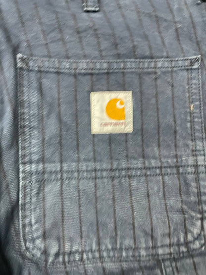 Carhartt navy shorts with pinstripe pattern, utility pockets, and branded metal button.