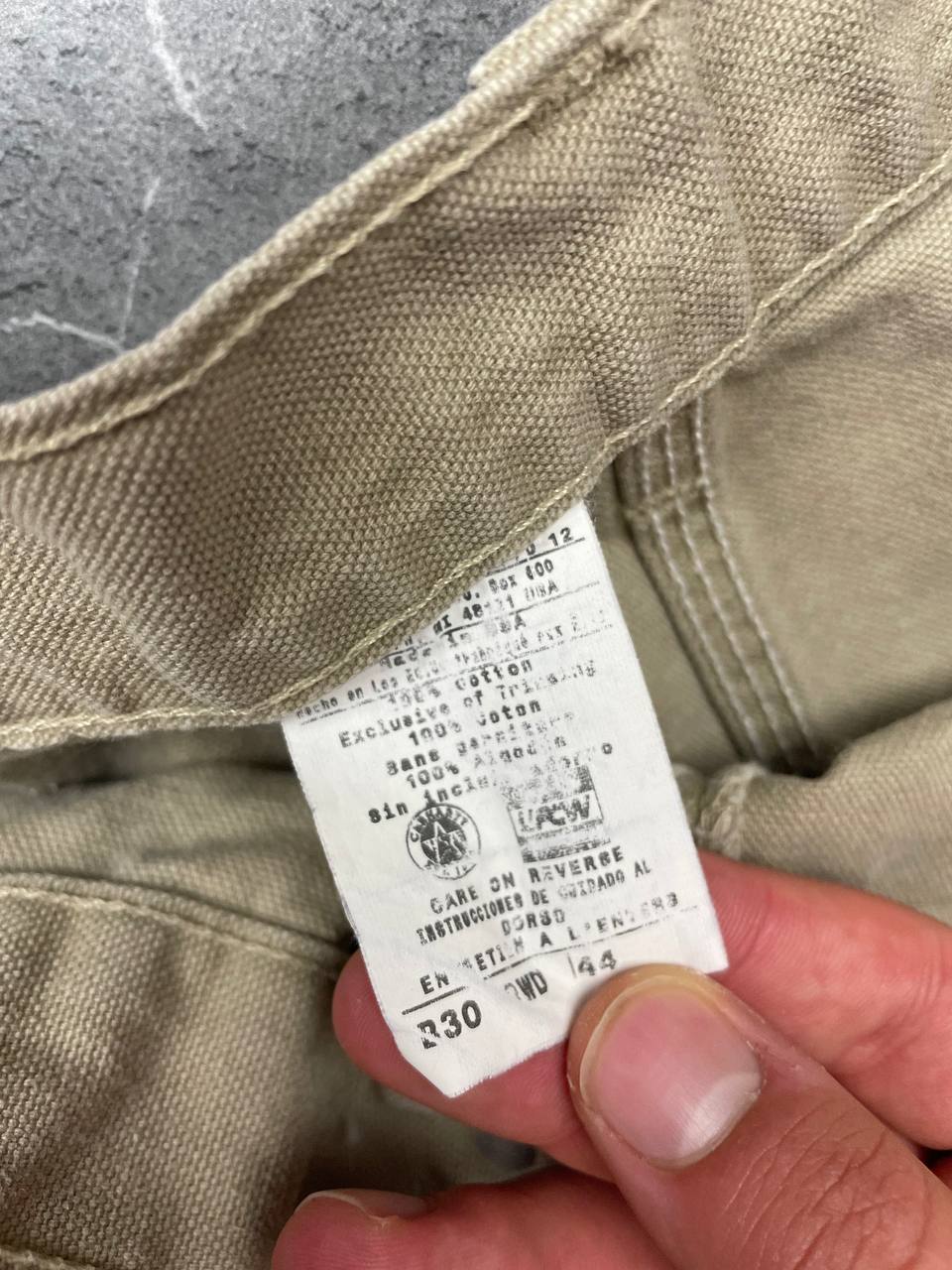 Carhartt beige cotton work shorts relaxed fit with logo patch and multiple pockets.
