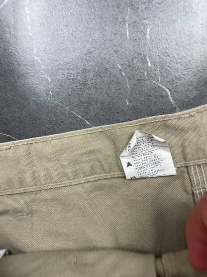 Carhartt beige cotton work shorts relaxed fit with logo patch and multiple pockets.