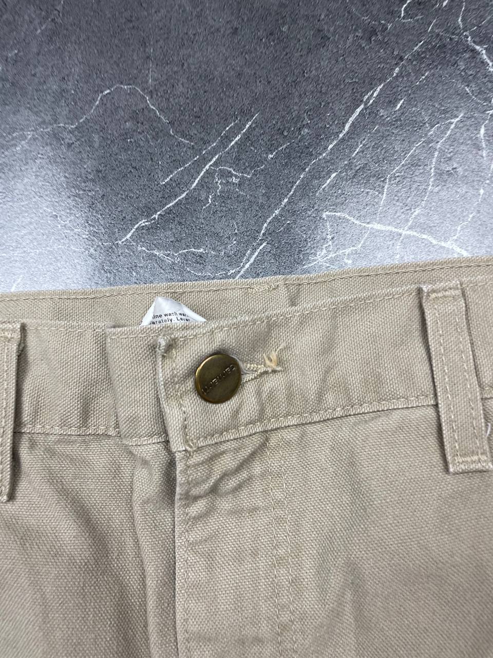 Carhartt beige cotton work shorts relaxed fit with logo patch and multiple pockets.