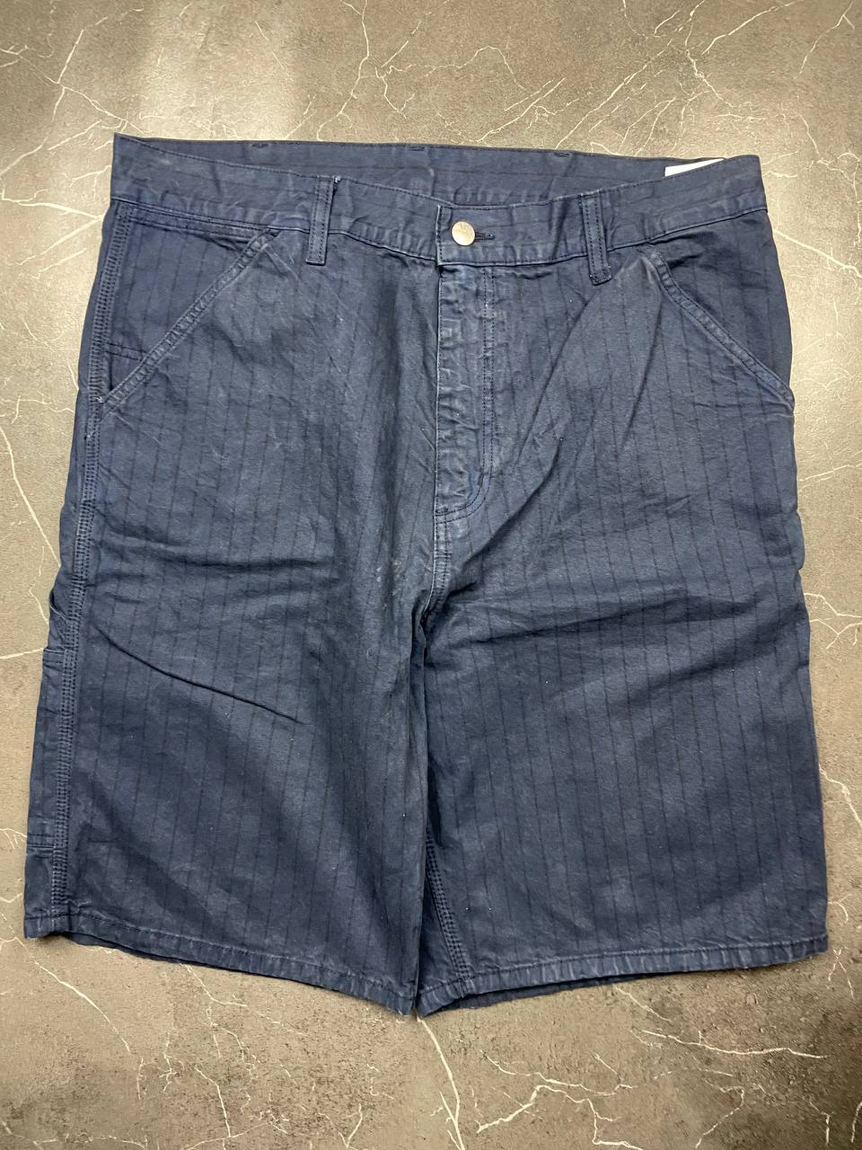 Carhartt navy shorts with pinstripe detail and logo patch on back pocket.