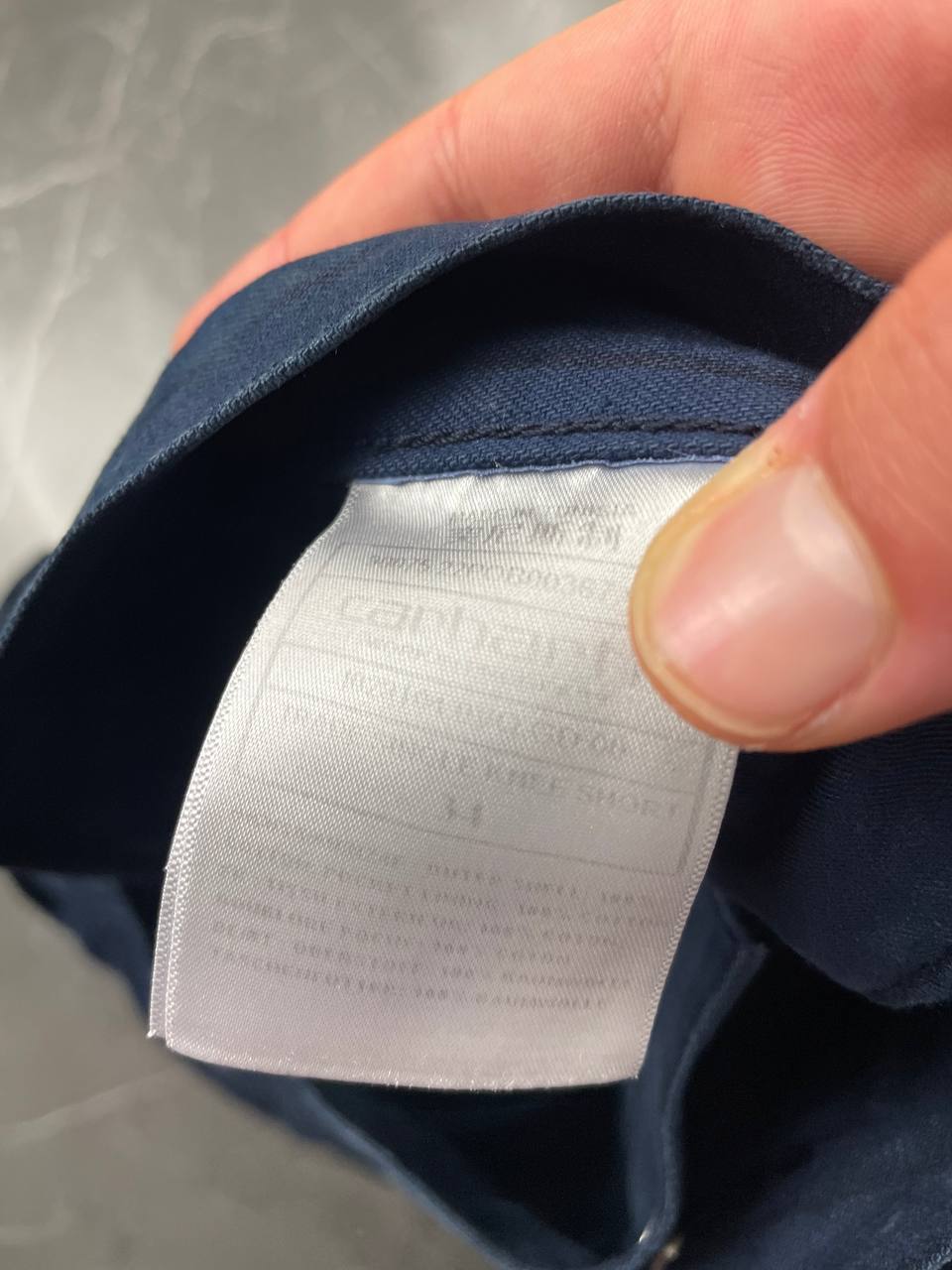 Carhartt navy shorts with pinstripe detail and logo patch on back pocket.
