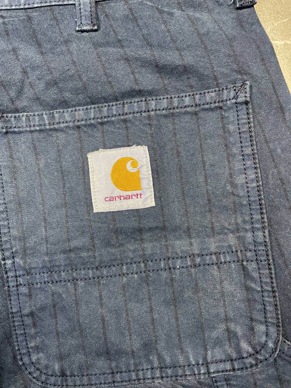 Carhartt navy shorts with pinstripe detail and logo patch on back pocket.