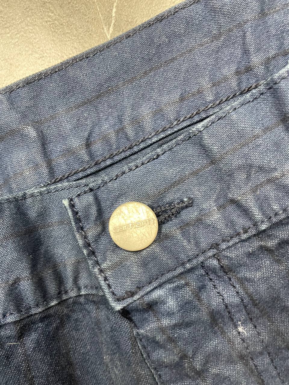 Carhartt navy shorts with pinstripe detail and logo patch on back pocket.