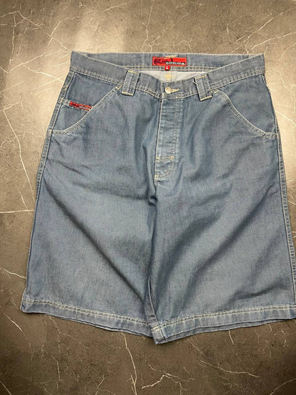 Quiksilver blue denim shorts with yellow contrast stitching and red logo patch.