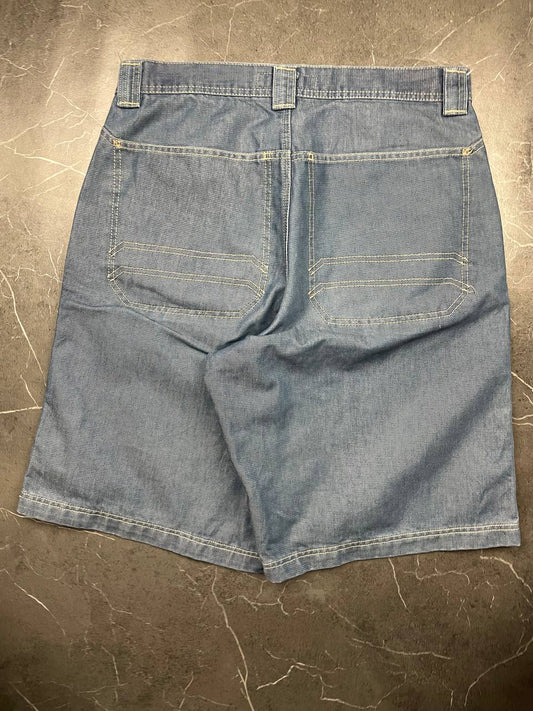 Quiksilver blue denim shorts with yellow contrast stitching and red logo patch.
