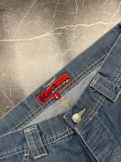 Quiksilver blue denim shorts with yellow contrast stitching and red logo patch.