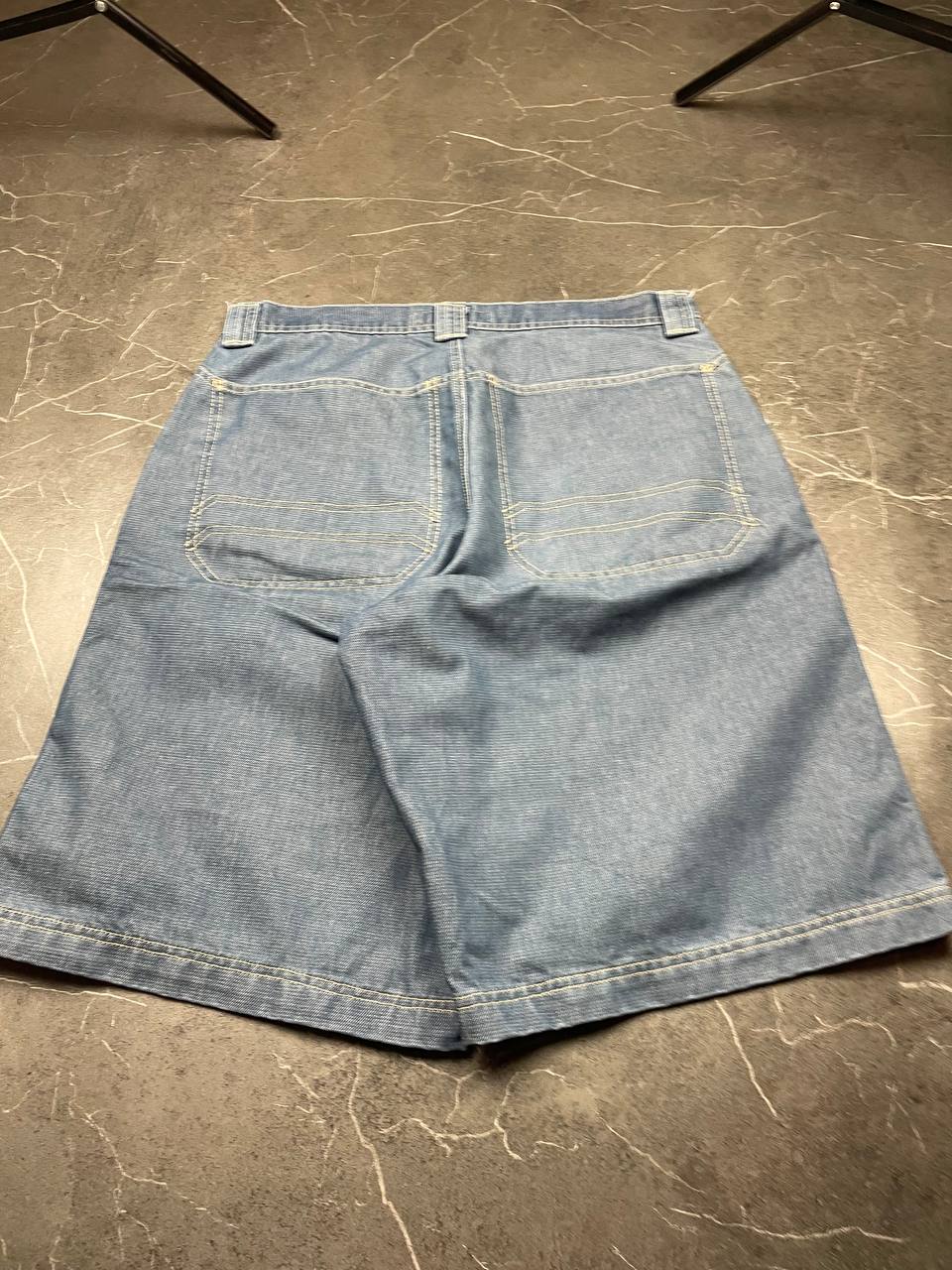 Quiksilver blue denim shorts with yellow contrast stitching and red logo patch.