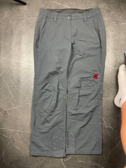 Mammut grey softshell outdoor trousers with reinforced knees, elastic waistband, and zipped pockets.