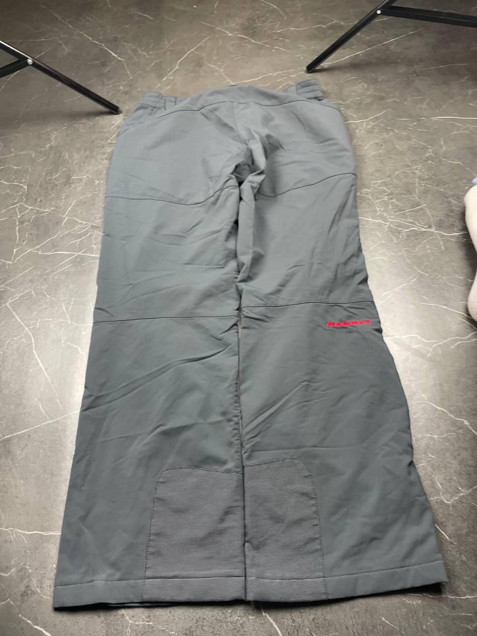 Mammut grey softshell outdoor trousers with reinforced knees, elastic waistband, and zipped pockets.