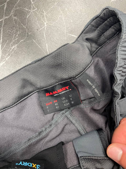 Mammut grey softshell outdoor trousers with reinforced knees, elastic waistband, and zipped pockets.