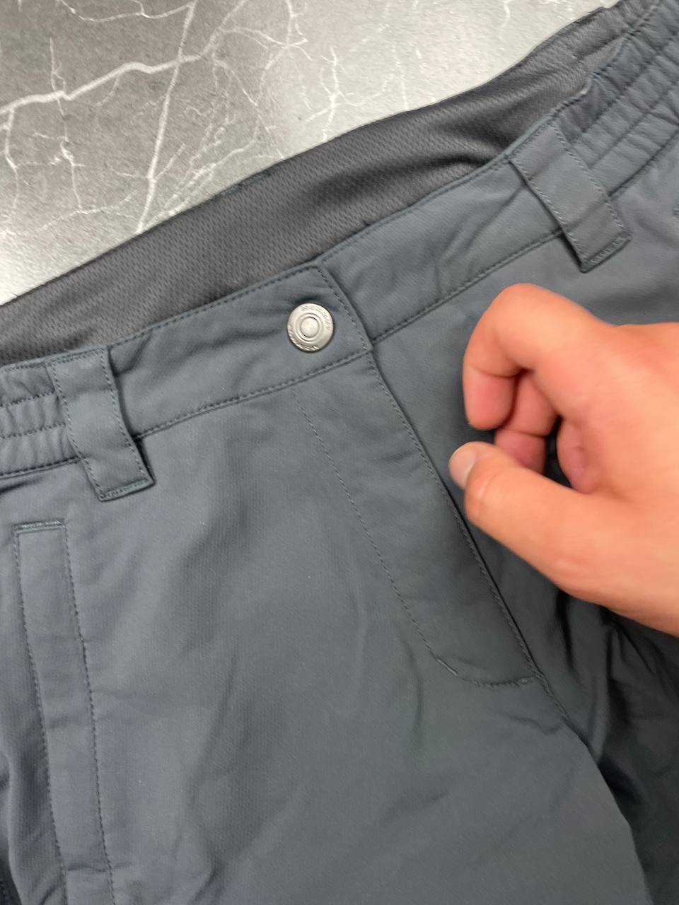 Mammut grey softshell outdoor trousers with reinforced knees, elastic waistband, and zipped pockets.