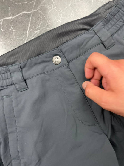 Mammut grey softshell outdoor trousers with reinforced knees, elastic waistband, and zipped pockets.