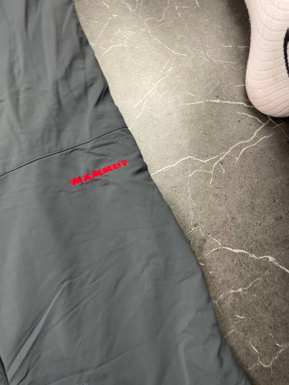 Mammut grey softshell outdoor trousers with reinforced knees, elastic waistband, and zipped pockets.