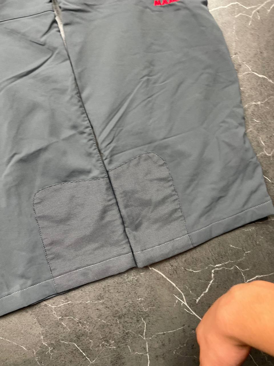 Mammut grey softshell outdoor trousers with reinforced knees, elastic waistband, and zipped pockets.