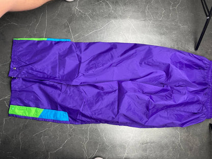 Nike track pants purple with blue and green accents, nylon material, elastic waistband.