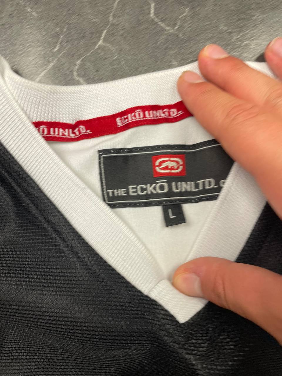 Ecko Unltd black vintage graphic t-shirt with white V-neck collar and blue face design.