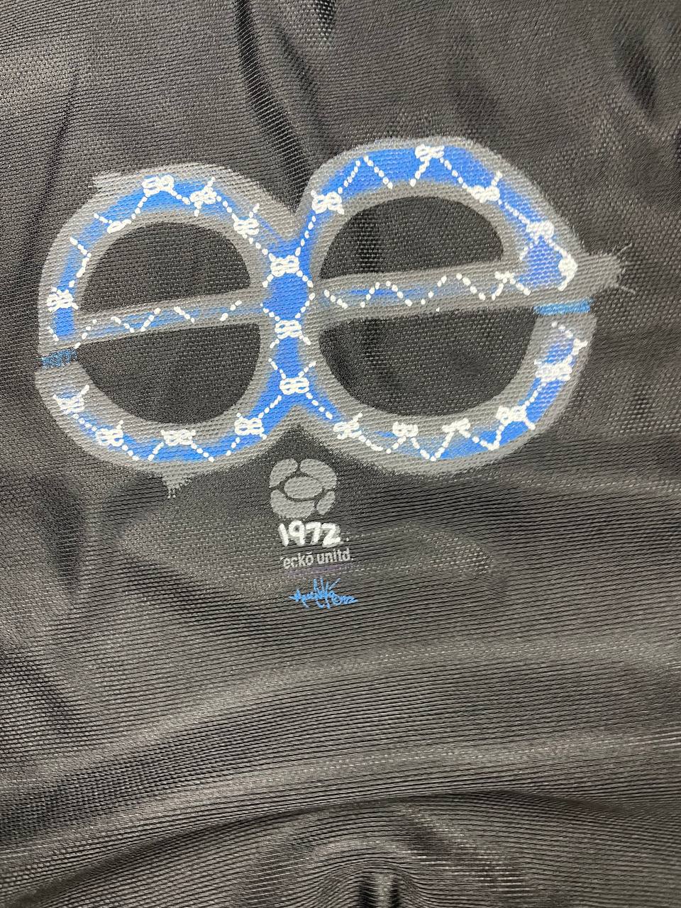 Ecko Unltd black vintage graphic t-shirt with white V-neck collar and blue face design.