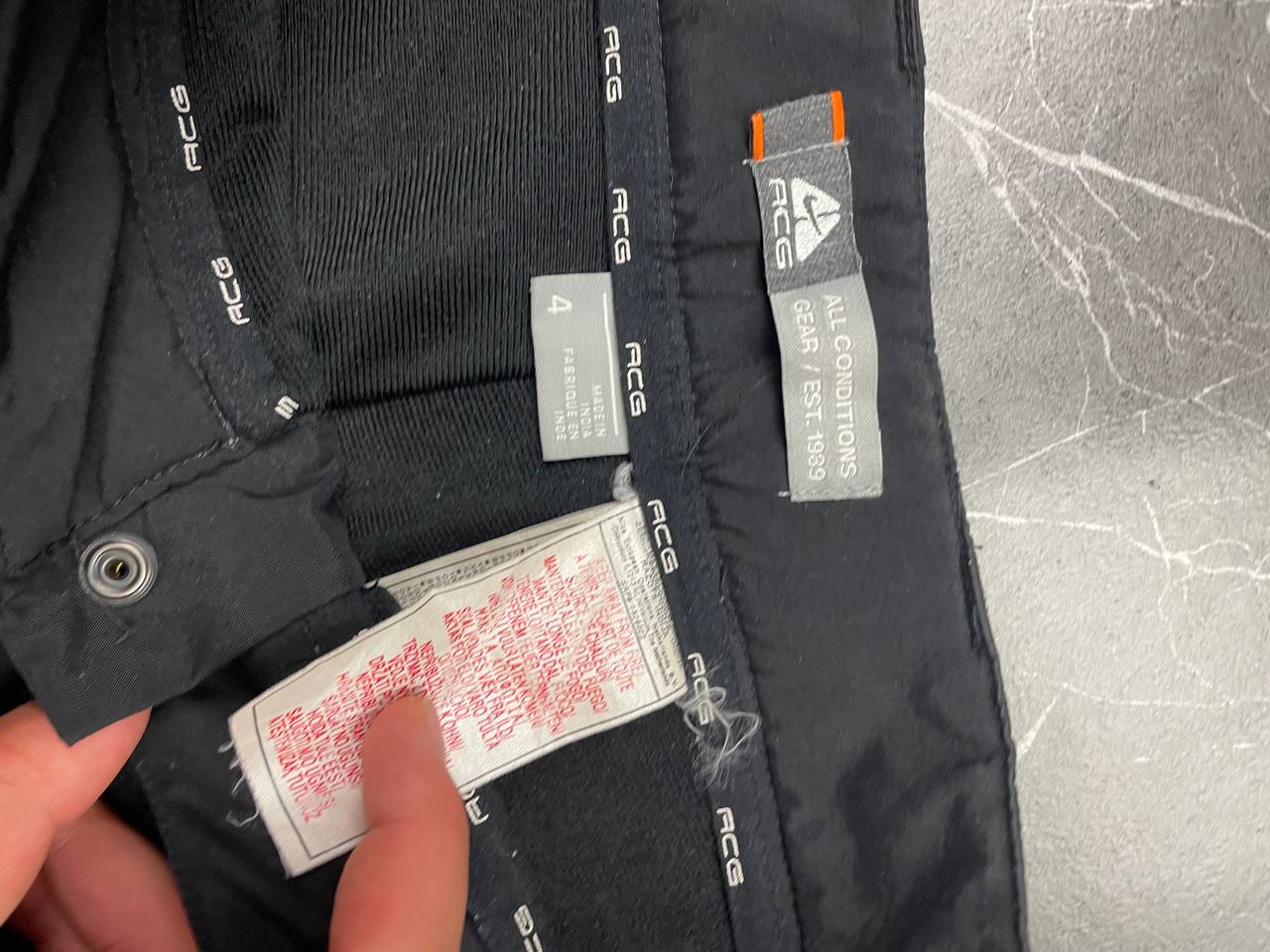 Nike black ACG outdoor pants, waterproof nylon, zip and button closure, zipped side pockets.