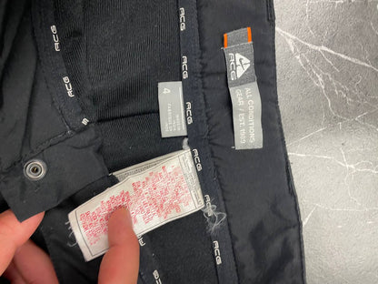 Nike black ACG outdoor pants, waterproof nylon, zip and button closure, zipped side pockets.