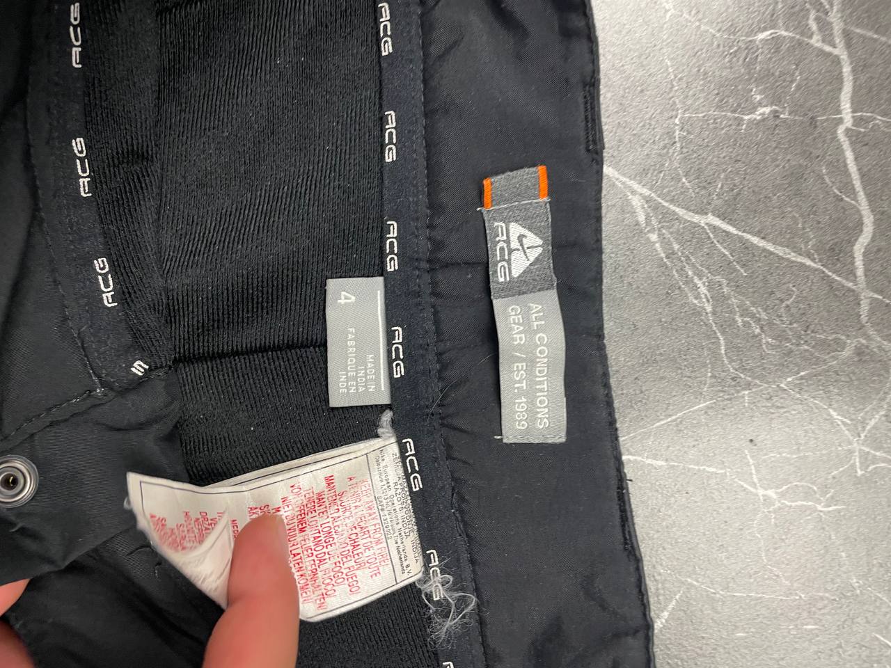 Nike black ACG outdoor pants, waterproof nylon, zip and button closure, zipped side pockets.