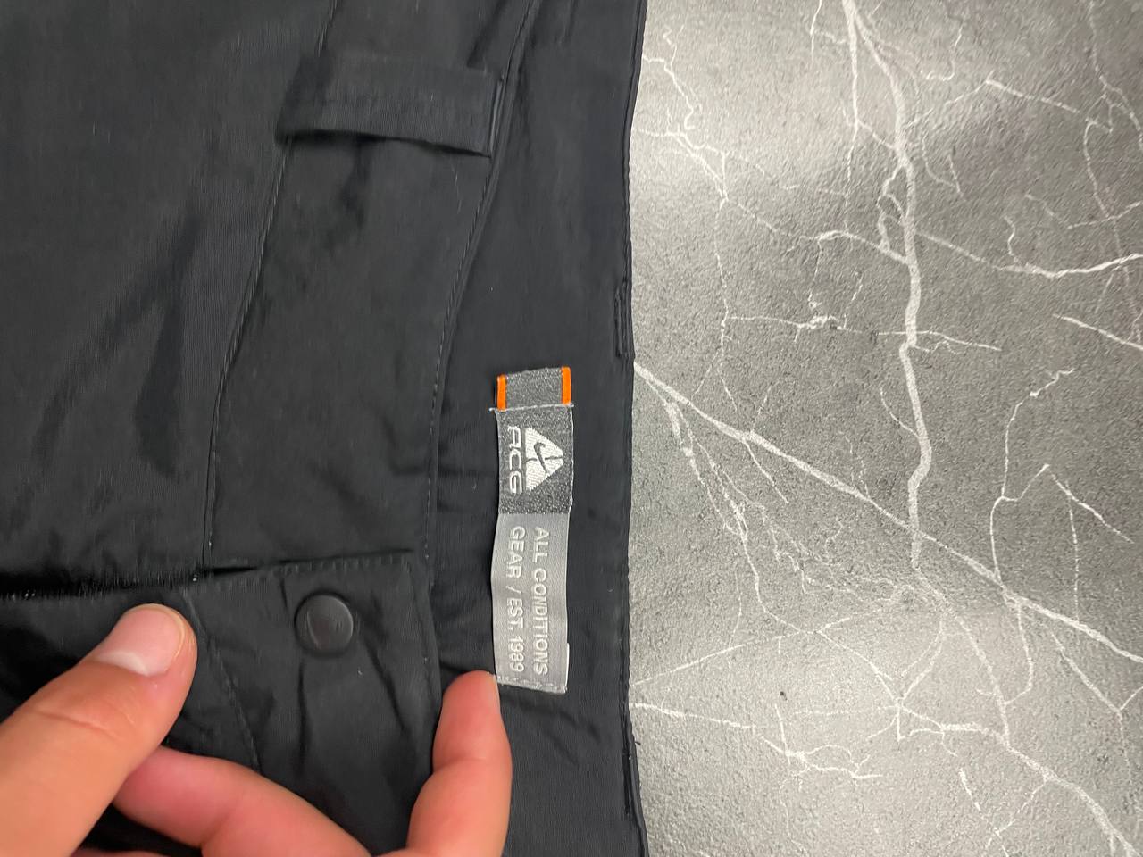 Nike black ACG outdoor pants, waterproof nylon, zip and button closure, zipped side pockets.