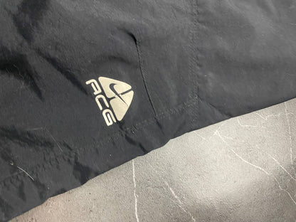 Nike black ACG outdoor pants, waterproof nylon, zip and button closure, zipped side pockets.