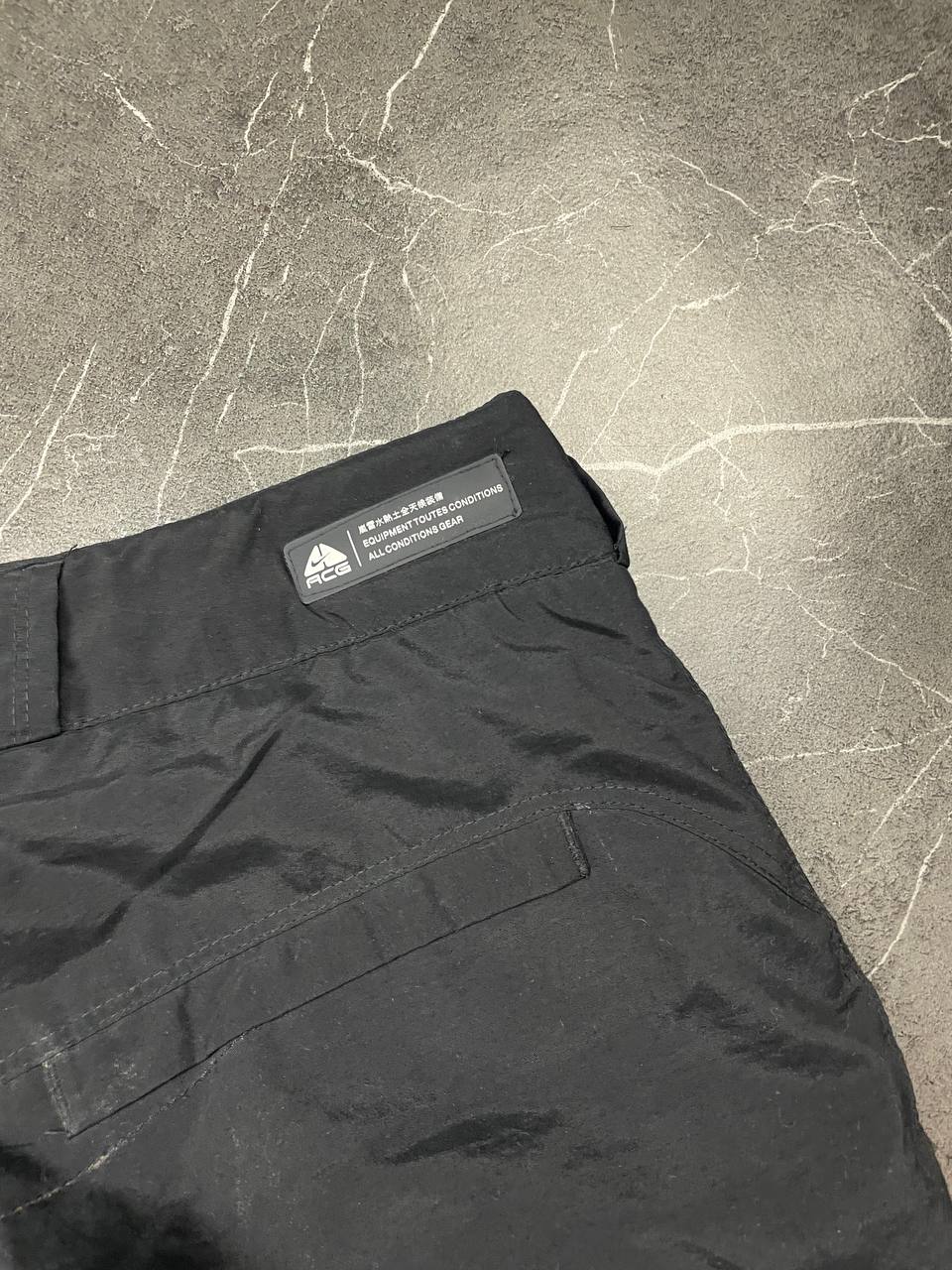 Nike black ACG outdoor pants, waterproof nylon, zip and button closure, zipped side pockets.