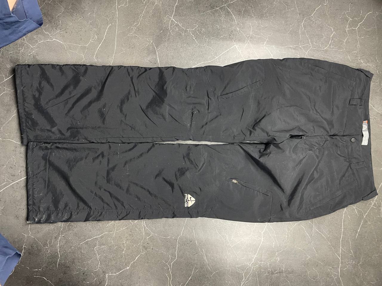Nike black ACG outdoor pants, waterproof nylon, zip and button closure, zipped side pockets.