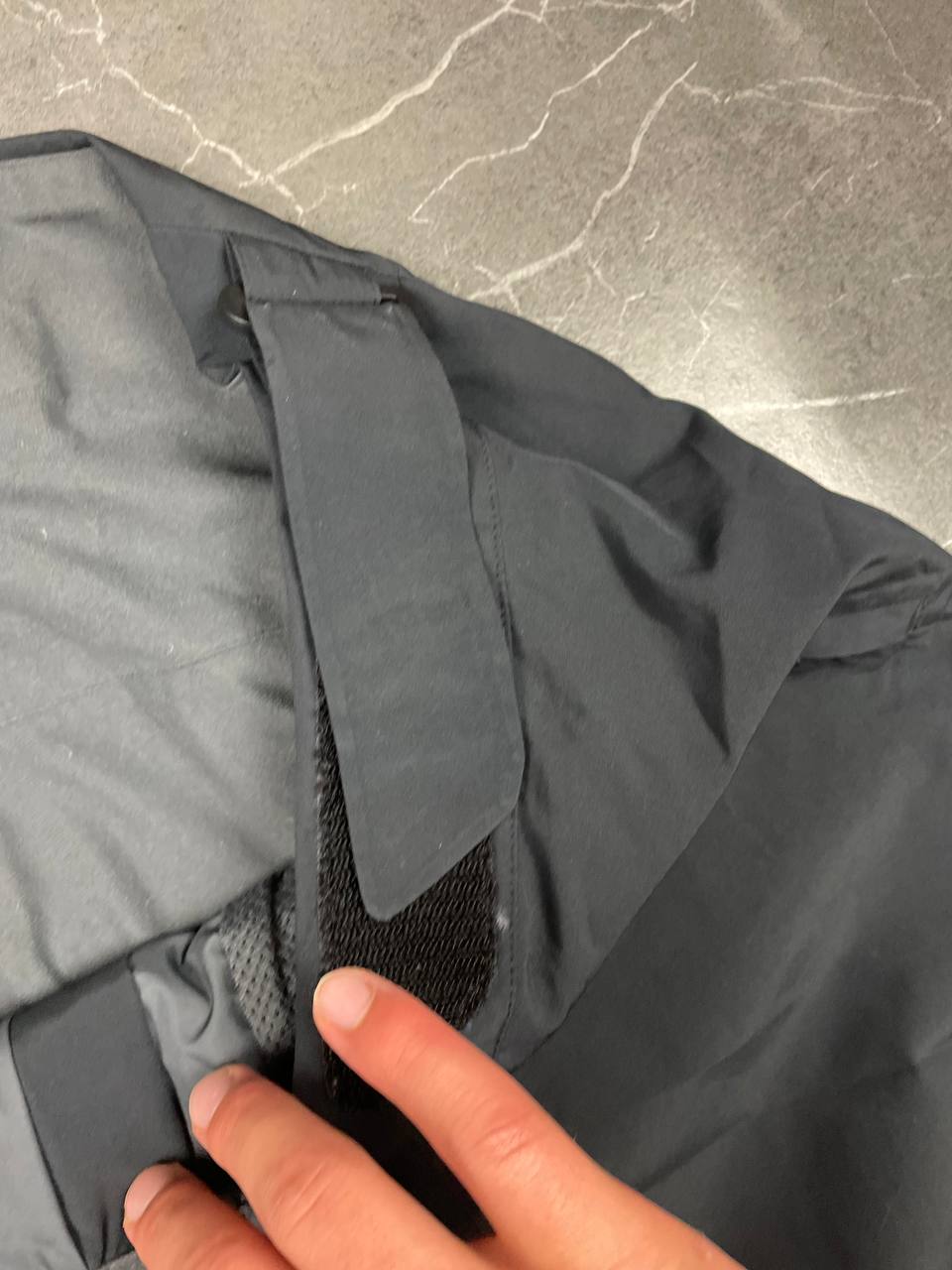 Haglöfs black softshell outdoor trousers with zipped pockets and adjustable Velcro waist tabs.