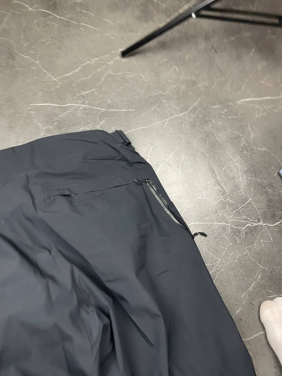 Haglöfs black softshell outdoor trousers with zipped pockets and adjustable Velcro waist tabs.