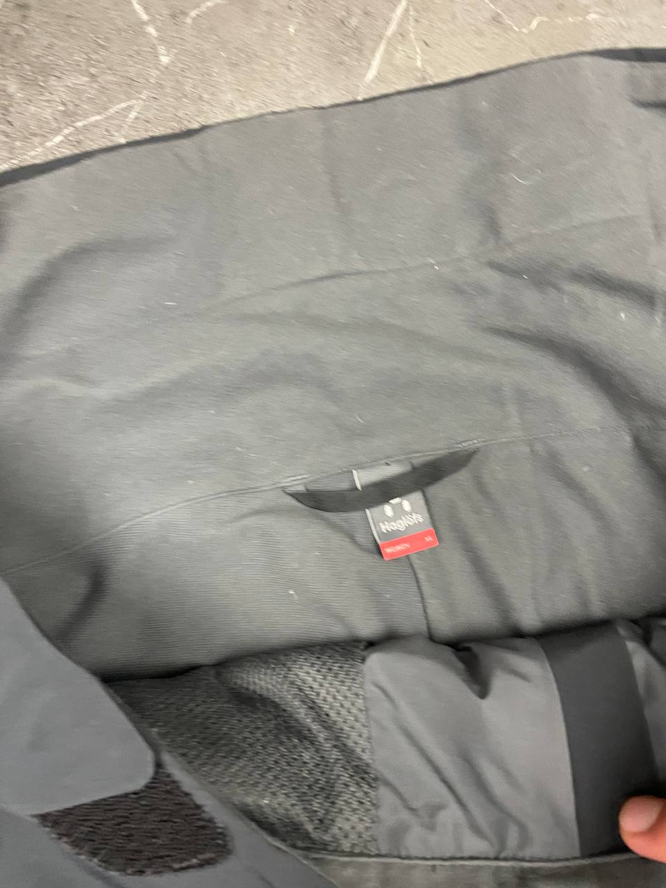 Haglöfs black softshell outdoor trousers with zipped pockets and adjustable Velcro waist tabs.
