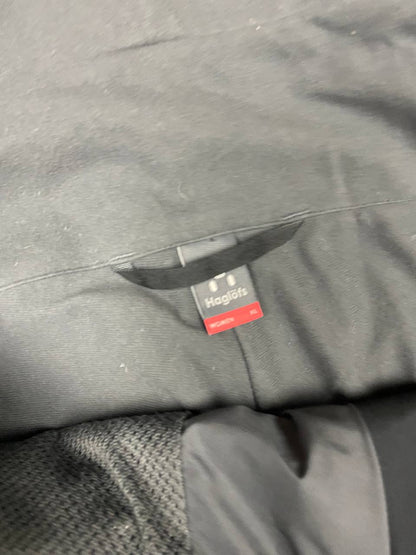 Haglöfs black softshell outdoor trousers with zipped pockets and adjustable Velcro waist tabs.