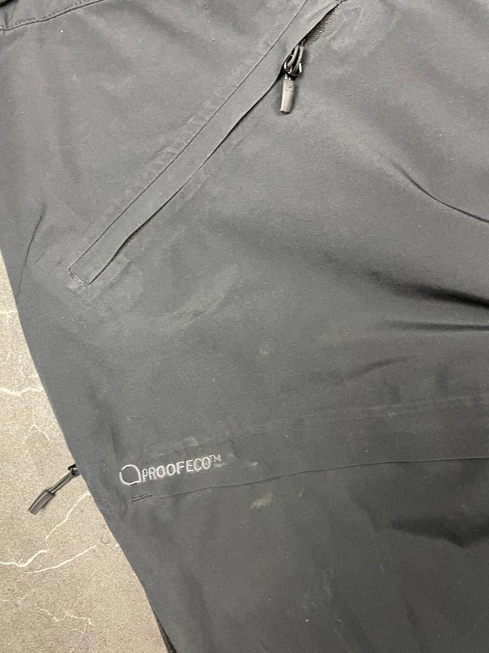 Haglöfs black softshell outdoor trousers with zipped pockets and adjustable Velcro waist tabs.