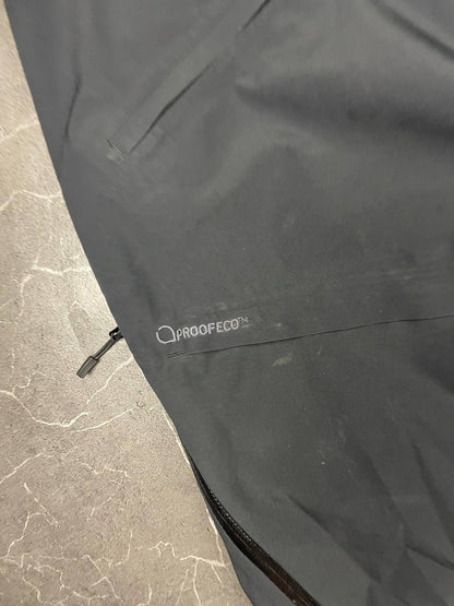 Haglöfs black softshell outdoor trousers with zipped pockets and adjustable Velcro waist tabs.
