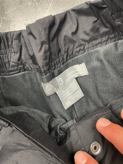 Nike black ski trousers with ACG branding, button closure, and elasticated waistband.