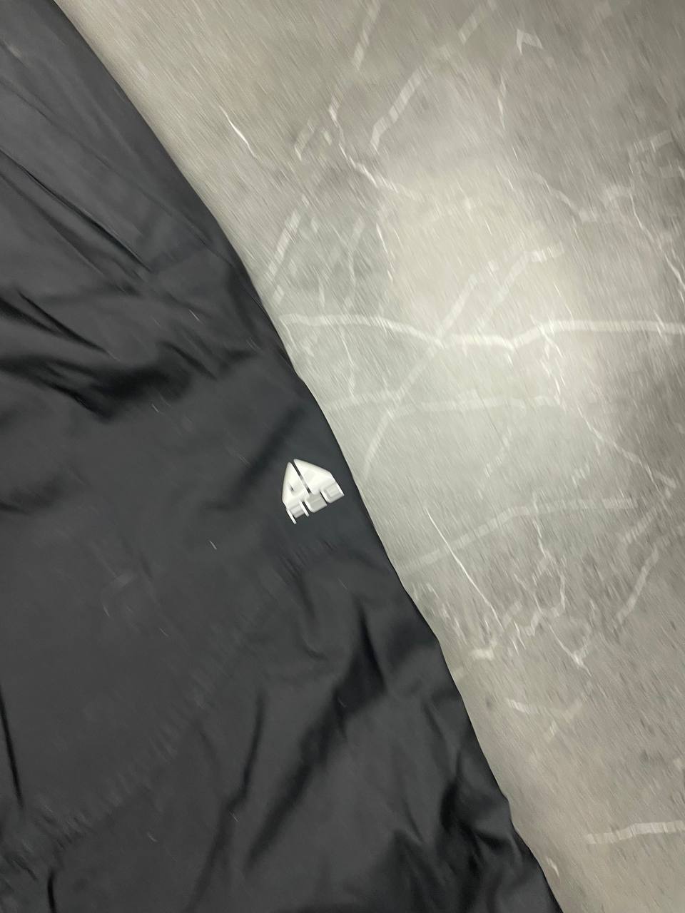 Nike black ski trousers with ACG branding, button closure, and elasticated waistband.