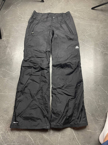 Nike black ski trousers with ACG branding, button closure, and elasticated waistband.