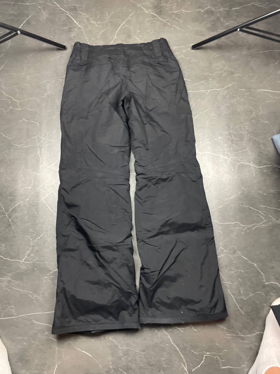 Nike black ski trousers with ACG branding, button closure, and elasticated waistband.