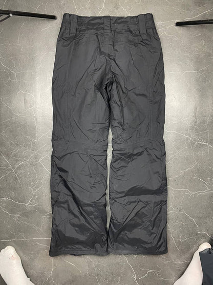 Nike black ski trousers with ACG branding, button closure, and elasticated waistband.