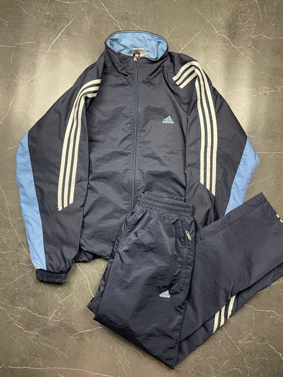 Adidas girls tracksuit navy blue with white stripes, full zip jacket and elastic pants.